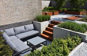 a patio with a couch and a table and plants at Vakantiewoning Lescaut in Hamme