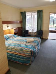 a hotel room with a bed and a table and chairs at Lacepede Bay Motel in Kingston South East