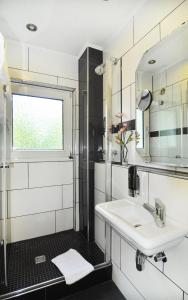 a bathroom with a sink and a mirror at Hotel Nüller Hof in Wuppertal