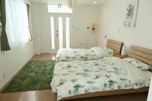 sypialnia z 2 łóżkami i zielonym dywanem w obiekcie Mkグリーンホテル w mieście Kawaguchi