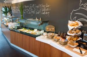 a buffet with bread and pastries on a table at Hotel Rheinpark Rees in Rees +28 photos