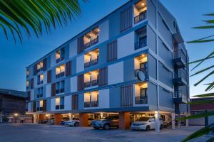 ラヨーンにあるPLAAI Play Hotelの駐車場車の入った建物