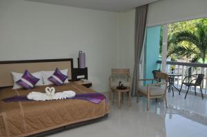 AM Surin Place - SHA Extra Plus في شاطئ سورين: غرفة نوم بسرير وشرفة
