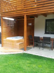 un patio con bañera de hidromasaje, mesa y sillas en Hiša Katja-Privat wellness, en Kranjska Gora