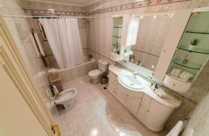 uma casa de banho com um lavatório, um WC e um espelho. em Four Seasons Vilamoura em Vilamoura