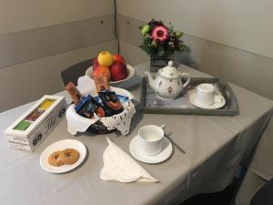 een tafel met een fruitschaal en een theeset bij Appartamenti del Corso in Cuneo