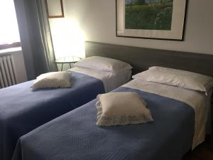 twee bedden naast elkaar in een kamer bij Appartamenti del Corso in Cuneo