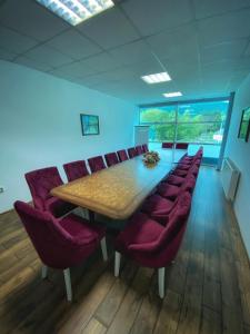 a conference room with a wooden table and red chairs at Hotel Turist 98 in Jajce