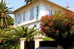 un edificio blanco con un cartel. en Hotel Villa Les Cygnes en Niza