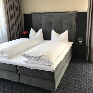a bed with two white pillows on it at Remstal Hotel in Weinstadt