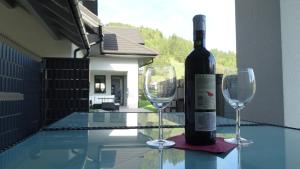 - une bouteille de vin assise sur une table avec 2 verres à vin dans l'établissement DOMINO-APARTAMENTY Green, à Krościenko nad Dunajcem