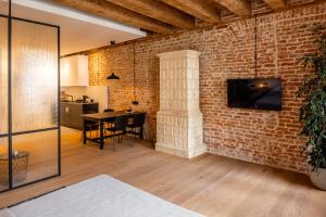 - un salon avec un mur en briques et une table dans l'établissement OnLviv Apartments Rynok Square 18, à Lviv