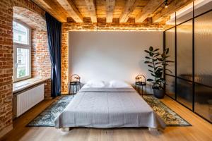 - une chambre avec un lit et un mur en briques dans l'établissement OnLviv Apartments Rynok Square 18, à Lviv