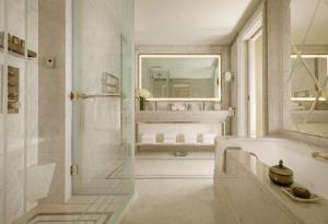 
a bathroom with a tub, sink, and mirror at The Parisian Macao in Macau
