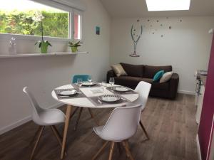 een woonkamer met een tafel en stoelen en een bank bij Maison Mitoyenne in Taissy