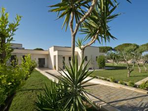 a house with palm trees in front of it at Otus Camere in Otranto