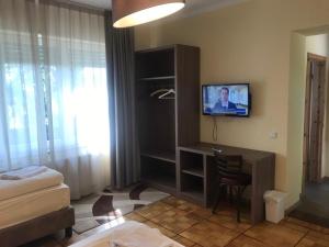 a room with a desk and a tv on a wall at Hotel Il Cavallino in Warendorf