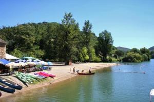 a beach with boats and umbrellas and people on it at Le Cintrium in Viala-du-Tarn