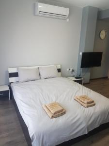 a bedroom with a white bed with towels on it at LUXURY SUITES 3 in Karlovo