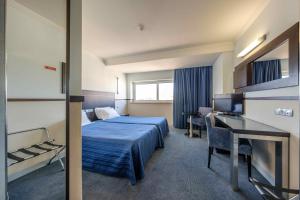 ファティマにあるHotel Santo Amaro - SA Hotelsのベッドとデスクが備わるホテルルームです。