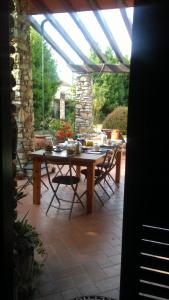 a wooden table and chairs on a patio at Pietra E Glicine B&B in Pieve a Nievole