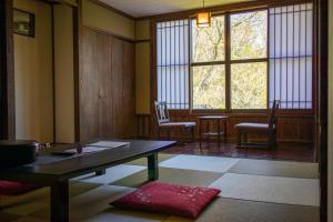 九重町にある旅館ななかまどのテーブルと椅子、窓が備わる客室です。