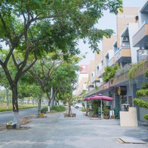 an empty street with trees and a building at Minh Hung Apartment & Hotel in Danang