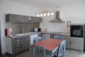 a kitchen with a table and chairs in it at Gite du Lac in Lourdes