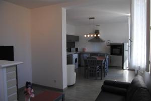a living room and kitchen with a couch and a table at Gite du Lac in Lourdes +4 photos