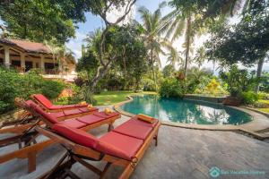 een zwembad met ligstoelen naast een huis bij Wonderful luxury hideaway surrounded by nature in Mayong