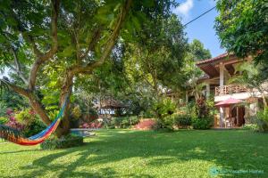 een hangmat hangend aan een boom in de tuin van een huis bij Wonderful luxury hideaway surrounded by nature in Mayong