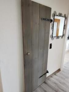 una puerta de madera con un espejo en la pared en Ferienwohnungen Blischke, en Carolinensiel
