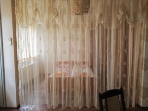 1 dormitorio con 1 cama y una ventana con cortinas en Хотелски Комплекс Родина, en Mezdra