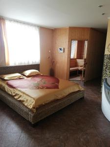 MizaraにあるХотелски Комплекс Родинаのベッドルーム(大型ベッド1台付)、バスルームが備わります。