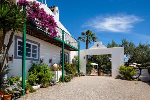 a white house with flowers on the side of it at Casa Vale Del Rei in Tavira