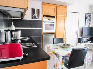 una cocina con un aparato rojo en una encimera en Cabourg, cosy appartement avec balcon + parking privé, en Cabourg
