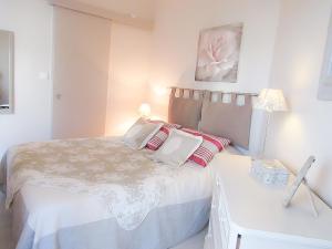 Habitación blanca con cama y escritorio en Cabourg, cosy appartement avec balcon + parking privé, en Cabourg