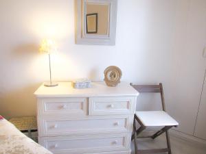 Vestidor blanco con lámpara y silla en Cabourg, cosy appartement avec balcon + parking privé, en Cabourg