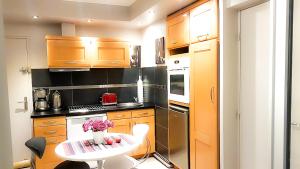 una pequeña cocina con mesa y mesa blanca en Cabourg, cosy appartement avec balcon + parking privé, en Cabourg