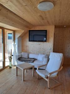 a living room with a couch and a tv on a wall at Jagdhaus im Grünen, mit Sauna in Kulmbach