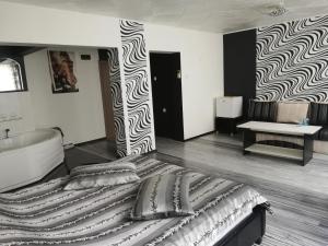 MizaraにあるХотелски Комплекс Родинаのベッドルーム(大型ベッド1台、バスタブ付)