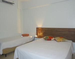 a bedroom with two beds and a wooden headboard at Senador Plaza Hotel in Senador Canedo