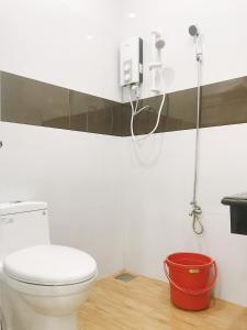 a bathroom with a toilet and a red bucket at Hoa Trang Hotel in Tuy An