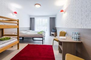 a bedroom with two bunk beds and a red rug at Ośrodek Wypoczynkowy Gwarek Mazury in Giżycko