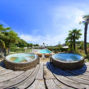 two large hot tubs in a resort with a pool at Relais Bellaria Hotel & Congressi in Bologna