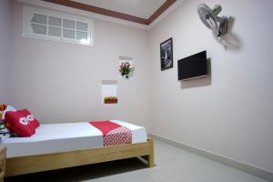 een witte kamer met een bed en een televisie bij OYO 987 Thanh Thanh Nhan Hotel in Da Lat