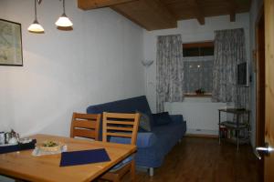 a living room with a blue couch and a table at Fasslreiter in Achenkirch