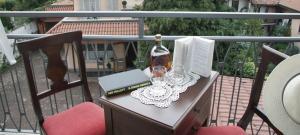 een tafel met een fles wijn en glazen op een balkon bij Hotel La Locanda in Stresa