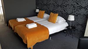 zwei Betten in einem Hotelzimmer mit Handtüchern darauf in der Unterkunft Hotel Molengroet in Noord-Scharwoude