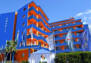 a blue hotel with flags in front of it at Amaris Hotel - All inclusive - Free parking in Sunny Beach